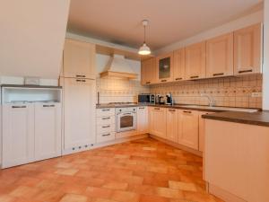 a kitchen with white cabinets and a wooden floor at Holiday Home La casa dei Noci by Interhome in Madice