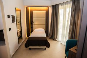 a hospital room with a bed and a mirror at Hotel Perla del Gargano in San Giovanni Rotondo