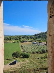 Una vista de un campo desde una ventana vieja en Studio cosy à callas avec vue dégagée, en Callas