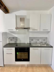 Una cocina blanca con fregadero y estufa. en Studio cosy à callas avec vue dégagée, en Callas 4 fotos más