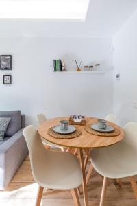 a dining room table with white chairs and a table at Residencias Bernabéu in Madrid