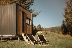 a group of chairs sitting next to a cabin at Refuge panoramique en Haute-Loire in Saint-Julien-Molhesabate