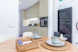 a kitchen with a table with two plates and a chalkboard at Residencias Bernabéu in Madrid +13 photos
