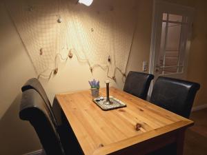 a wooden table with black chairs and a vase on it at Haus am Meer Whg3 in Rerik