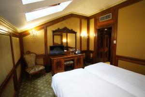 a bedroom with a bed and a desk and a mirror at Hotel Casa Capsa in Bucharest