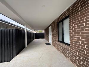a walkway between a brick wall and a building at Bran new home with ducted AC to stay in Sydney in Oakhurst