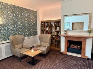 a living room with two chairs and a fireplace at AMBER HOTEL Bavaria Superior in Bad Reichenhall +46 photos