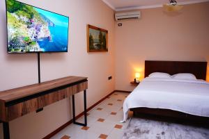 a bedroom with a bed and a flat screen tv on the wall at Vila 15 By Nam Nam Tirane in Tirana
