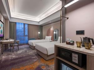 a hotel room with a bed and a desk at Mercure Beijing Downtown in Beijing