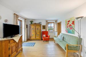 a living room with a couch and a tv at Landhaus Kauderer - Wohnung 1 in Waging am See