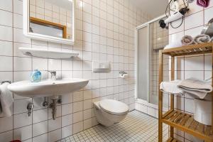 a white bathroom with a sink and a toilet at Landhaus Kauderer - Wohnung 1 in Waging am See +25 photos