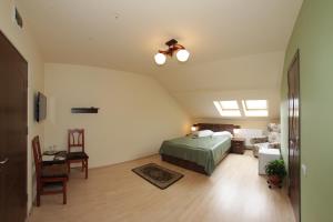 a bedroom with a bed and a couch and a table at Pensiunea Muresul in Târgu-Mureş