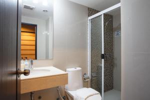 ein Badezimmer mit Toilette, Waschbecken und Dusche in der Unterkunft Harmony Living Condominium in Makkasan