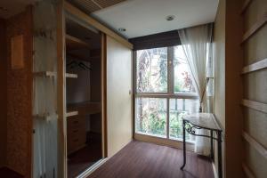 Zimmer mit einem großen Fenster und Holzboden in der Unterkunft Harmony Living Condominium in Makkasan