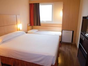 Un pat sau paturi într-o cameră la ibis Contagem Ceasa