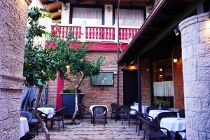 a patio with tables and chairs in front of a building at Vila 15 By Nam Nam Tirane in Tirana