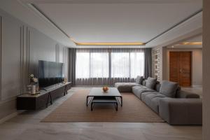 a living room with a couch and a tv at Lanna Fusion in Hang Dong