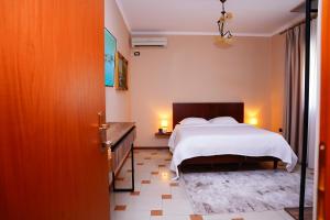 a bedroom with a bed and a table with two lamps at Vila 15 By Nam Nam Tirane in Tirana