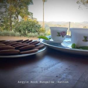 two plates with hot dogs and cups on a table at Argyle Rock Bungalow in Hatton