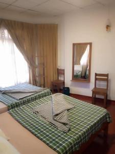 a bedroom with two beds with a green and white blanket at Argyle Rock Bungalow in Hatton