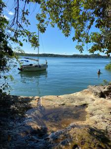 a boat on a lake with a person swimming in it at Passeio com o Veleiro Ventão in Aracaju
