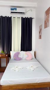 a bed with two swans pillows on it at Nowhere Siqujor Hostel in San Juan +17 photos