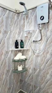 a shower in a bathroom with a stone wall at Nowhere Siqujor Hostel in San Juan