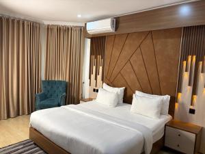 a hotel room with a bed and a blue chair at Cologne Residence in Mama