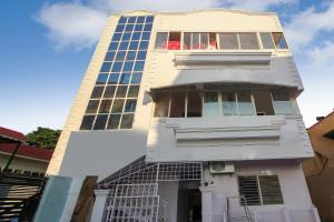 a tall white building with a lot of windows at Hotel O New Banjara Residency in Hyderabad