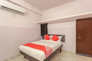 a bedroom with a bed with red pillows at Hotel O New Banjara Residency in Hyderabad