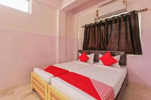 a bedroom with a bed with red pillows at Hotel O New Banjara Residency in Hyderabad +21 photos