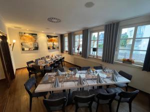a dining room with tables and chairs and windows at Hotel & Restaurant zum Ritter in Attendorn