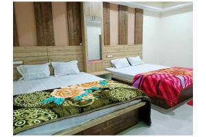 a bedroom with two beds and a mirror at Near Sea Beach HOTEL GANGA ARTI !NN ! Digha, Prime Location Near Jagannath Temple- Fully Air conditioned Rooms ,Wifi -Lift and Restaurant, Parking Facilities - A Top Rated Hotel IN DIGHA in Salt Lake City