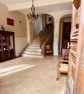 a living room with stairs and a chandelier at Château du Mesnil Soleil , gites et chambres d'hôtes in Damblainville +47 photos