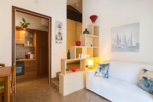 a living room with a white couch and a kitchen at Paradise house & garden in Lignano Sabbiadoro