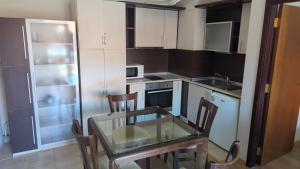 a small kitchen with a glass table and chairs in it at Borovets Apartments, Flora Violet Residence in Borovets