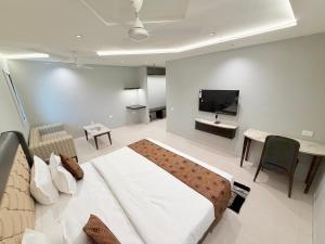a bedroom with a bed and a tv in a room at Hotel Nova Vista in Rajkot