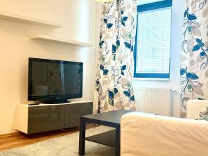 a living room with a television and a couch at Urban stay Bratislava City in Bratislava
