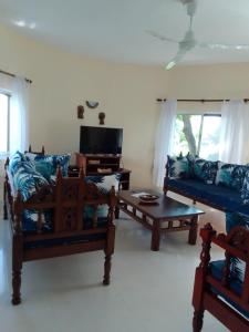 ワタムにあるSikuMoja Watamu 4 Bed HolidayHomeのソファ2つとテレビのあるリビングルーム