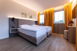 a bedroom with two beds and a large window at Lorenzhaus Exclusive Residence in Sankt Lorenz