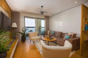 a living room with a couch and a table and chairs at La Terrazza at Marina - By AppartAli in Casablanca-Port
