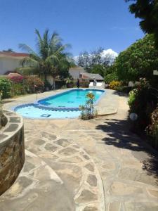 ワタムにあるSikuMoja Watamu 4 Bed HolidayHomeの石造りの通路のある庭の大きなスイミングプール