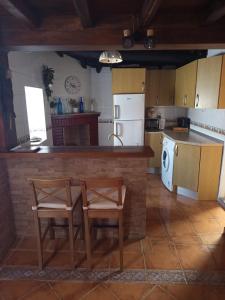 a kitchen with a table and two chairs and a counter at Casa rural TIO PEDRITO in Robledillo