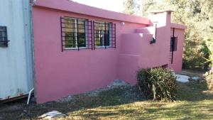 a pink house with windows on the side of it at Peckes in Balneario Buenos Aires +5 photos