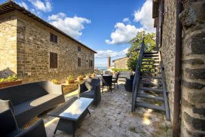a patio with a staircase and tables and chairs at Drogheria e Locanda Franci in Montalcino