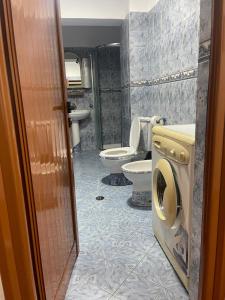 a bathroom with two toilets and a washer and dryer at Ermal's House in Fier