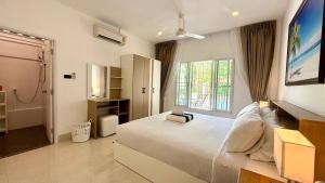ein Schlafzimmer mit einem großen weißen Bett und einem Fenster in der Unterkunft Secret Valley near Phuket Town in Kathu