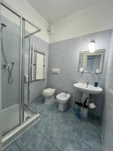 a bathroom with a toilet and a sink and a shower at La Maison di Bea in Manfredonia