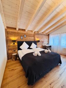 a bedroom with a large bed in a room with wooden ceilings at Typically Swiss Hotel Ermitage in Kandersteg