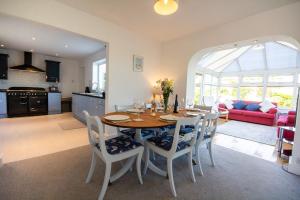 a kitchen and living room with a table and chairs at Lydgate, Benllech - Sleeping 6 in Benllech